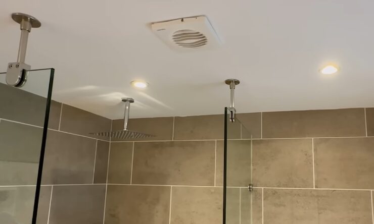 A modern shower featuring a clear glass door and a sleek shower head mounted on the wall