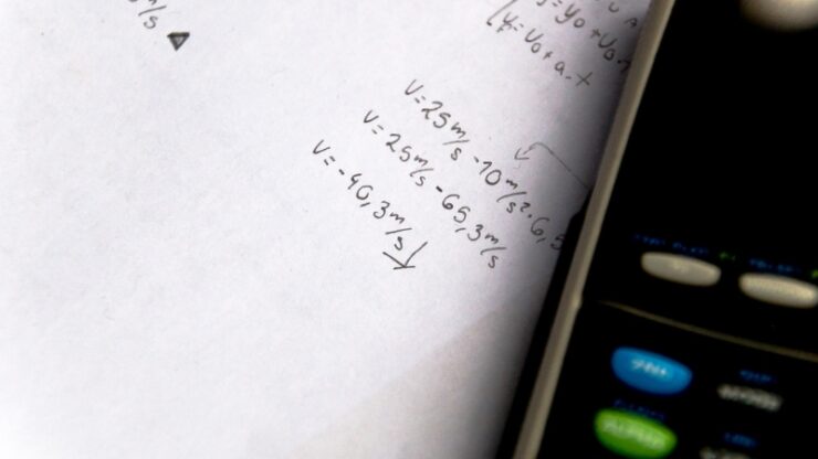 Handwritten physics notes beside a calculator show a focused daily study session for physics concepts