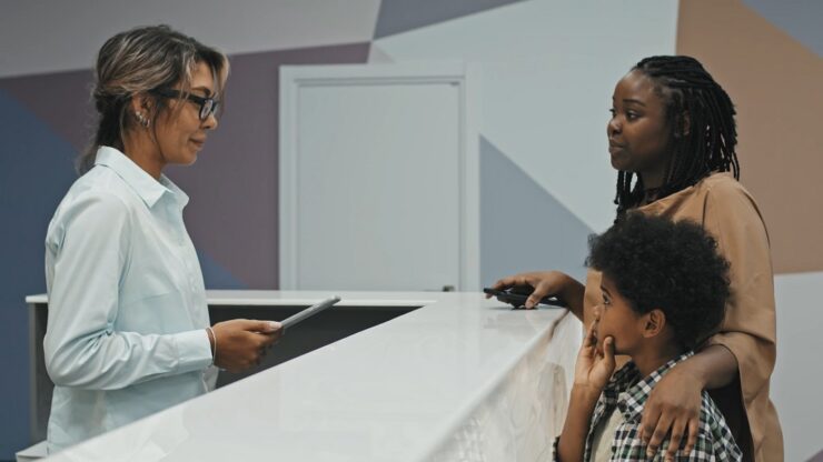 Front desk interaction demonstrating inclusive communication and patient focused service in a clinic