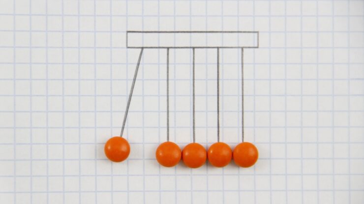 Newton’s cradle on graph paper shows forces and constraints in basic physics concepts
