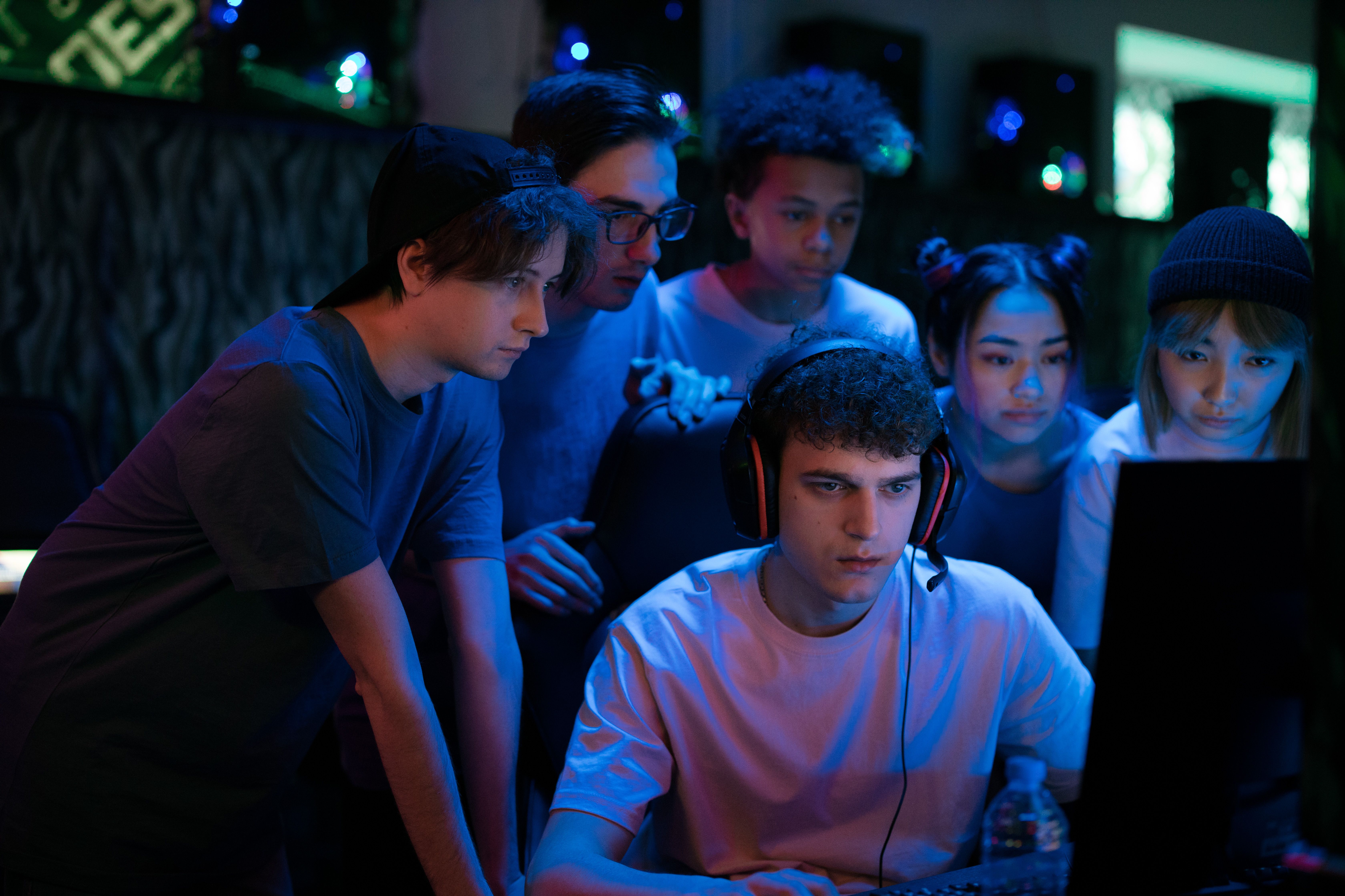 A group of gamers watching a screen intently, reflecting the shared anticipation of following a live game.